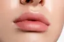 Zbliżenie na pełne, różowe usta z widocznymi detalami skóry.