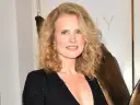 Wiktoria Gorodeckaja z burzą blond loków i złotą biżuterią, uśmiecha się na tle logo filmowego.