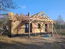 Budowa domu szkieletowego w toku. Widoczna konstrukcja dachu i ściany zewnętrzne. Zastanawiasz się, ile kosztuje dom szkieletowy?