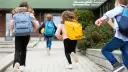 Niños corren con mochilas, ¡parece que ya empiezan las vacaciones de invierno!