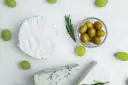 Ser brie, pleśniowy i winogrona otaczają miseczkę z oliwkami. Czy oliwki są lekkostrawne?