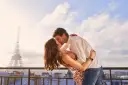 Parażanka i jej ukochany całują się na balkonie z widokiem na Wieżę Eiffla. To idealny moment, by pokazać, dlaczego facet całuje.