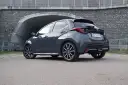 Szary Toyota Yaris Hybrid stoi przed tunelem. Dowiedz się, ile pali Toyota Yaris Hybrid, analizując jego osiągi.