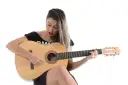 Kobieta gra na gitarze, nucąc stare piosenki country.