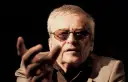 Jerzy Jarocki w okularach, z gestem dłoni, w ciemnym tle.