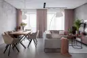 Nowoczesne wnętrze z jadalnią i salonem, szara sofa, drewniany stół, różowe zasłony.