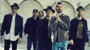 Sechs Männer der Band Linkin Park stehen nebeneinander, einige tragen Hüte und Jacken.