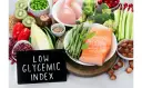 Łosoś, kurczak, warzywa, owoce i orzechy na tle tabliczki z napisem "Low Glycemic Index".