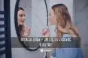 Kobieta używa irygatora do zębów przed lustrem. Dowiedz się, jak często stosować irygator dla zdrowego uśmiechu.