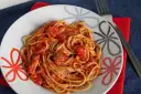 Pyszne spaghetti napoli przepis na talerzu, z sosem pomidorowym i ziołami. Idealne danie dla miłośników włoskiej kuchni.
