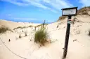 Plaża z wydmami i znakiem "Obszar objęty ścisłą ochroną". Może to miejsce, gdzie kręcono Seks-misję, z charakterystycznymi, surowymi krajobrazami.
