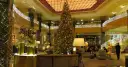 Elegancka wigilia w hotelu. Ogromna choinka, złote dekoracje i migoczące światełka tworzą magiczną atmosferę.