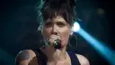 Beth Hart z tatuażem na ramieniu, w okrągłych kolczykach, śpiewa do mikrofonu. Choć nie widać jej dzieci, jej energia na scenie jest jak dla nich.