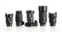 Pięć obiektywów do aparatów Sony Alfa i jeden aparat Sony Alfa na białym tle.