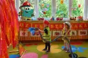 Dzieci gaszą pożar, świetne pomysły na dni otwarte w przedszkolu! Maskotka-książka w stroju strażaka zachęca do zabawy.