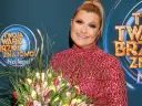 Małgorzata Szudarska Kuszewska z bukietem tulipanów na tle logo "Twoja twarz brzmi znajomo".