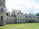 Dawny pałac bożków, zniszczony i opuszczony, z charakterystycznymi okrągłymi oknami i wieżą.