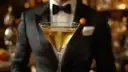 Elegancki mężczyzna w smokingu podaje Martini wstrząśnięte czy zmieszane. Złocisty trunek w kieliszku, idealnie schłodzony.