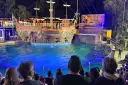 A pirate ship show at Zoomarine Roma with performers on a stage and in the water.