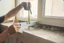 Precyzyjne pomiary to klucz do tego, jak zmierzyć parapet wewnętrzny. Poziomica i miarka pomagają w pracach remontowych.