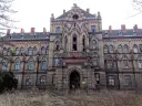 Imponujący pałac w Mokrzeszowie, zniszczony, z pustymi oknami i dziką roślinnością wokół.