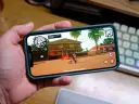 Ręka trzyma smartfon z grą GTA: San Andreas. To świetny przykład darmowe gry na komórkę, które pozwalają na wirtualną rozrywkę.