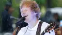 Ed Sheeran grający na gitarze podczas deszczu.