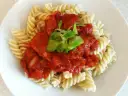 Fusilli z bogatym sosem passata pomidorowa, ozdobione świeżą zieleniną. Pyszne danie, które zadowoli każdego miłośnika włoskich smaków.