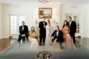 Para ślubna i drużba stoją w eleganckim wnętrzu.