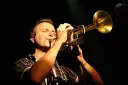 Muzyk gra na trąbce, zamykając oczy. Czy to synkopa co to? Muzyka jazzowa.