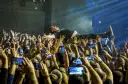 Kult w Arahji: wokalista zespołu niesiony przez tłum, fani nagrywają koncert telefonami.