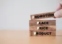Drewniane klocki z napisami: Product, Price, Place, Promotion.