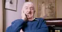 Jerzy Waldorff, znany z zamiłowania do kultury i sztuki, w niebieskim swetrze. Jego wykształcenie i pasje widoczne w tle.