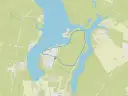 Mapa turystyczna z zaznaczoną trasą wokół **zalewu Koronowskiego**. Widoczne drogi, zabudowania i linie brzegowe.