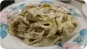 Pappardelle z kremowym sosem z mascarpone i aromatyczną pastą truflową, podane na talerzu z kwiatowym wzorem.