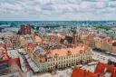 Wrocław słynie z kolorowych kamienic na Rynku i wież kościelnych. Widok z lotu ptaka na tętniące życiem miasto.