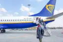 Pasażerowie wsiadają po schodkach do samolotu Ryanair.