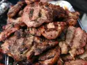 Soczysta karkówka z grilla, idealna po marynacie. Grillowane plastry mięsa z charakterystycznymi paskami.