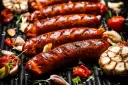 Soczyste kiełbaski na grillu, z czosnkiem i pomidorkami. Idealna odpowiedź na pytanie: jaka kiełbasa na grilla?