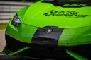 Przód zielonego Lamborghini Huracan z czarnym pasem i logo.