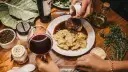 Elegancka kolacja z ravioli i wołowiną w sosie. Idealne pytanie: jakie wino do gotowania? Czerwone wino i świeże zioła dopełniają atmosferę.