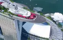 Widok z lotu ptaka na słynny singapur hotel statek z czerwonymi parasolami i basenem na dachu.