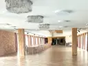 Elegancka sala weselna z kryształowymi żyrandolami i długimi stołami. Zastanawiasz się, ile kosztuje wesele na 120 osób w takim miejscu?