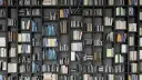 Eine Wand voller Bücherregale mit vielen Büchern in verschiedenen Farben und Größen.