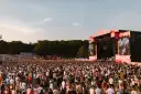 Tłum ludzi na festiwalu Bittersweet 2026, podziwiający scenę z wielkim ekranem i artystami. Słońce zachodzi, tworząc ciepłą atmosferę.