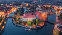 Ostrów Tumski we Wrocławiu nocą, z oświetlonymi budynkami i rzeką. To jedno z najpiękniejszych miejsc Wrocławia.