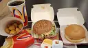 Zestaw McDonald's: burger, frytki, nuggetsy, napój i sosy.