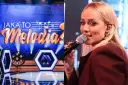 Jan Radwan śpiewa w programie "Jaka to melodia?". Na scenie widać neonowe dekoracje i logo programu.