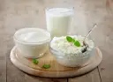 Kefir, jogurt i twaróg na drewnianej desce. Czy kefir jest dobry na odchudzanie? Te produkty to podstawa zdrowej diety.