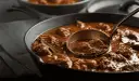 Gulasz w żeliwnej patelni, nabierany chochlą. Idealny przykład, jak zredukować sos, by był gęstszy i bardziej aromatyczny.